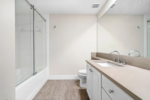 a bathroom with a double vanity sink toilet and shower