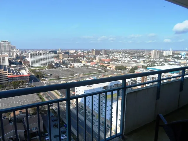 a view of roof deck with two chairs and wooden fence