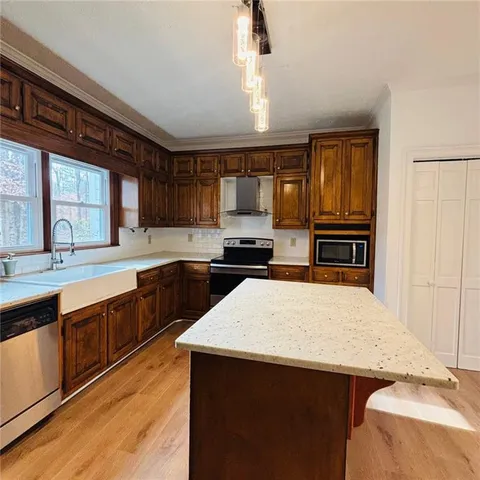 a kitchen with stainless steel appliances granite countertop a stove a sink and a refrigerator