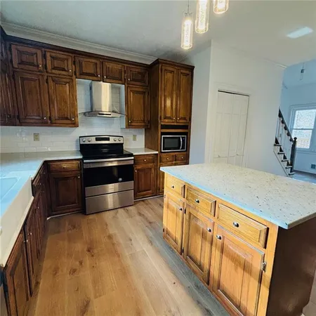 a kitchen with granite countertop a refrigerator stove top oven and sink