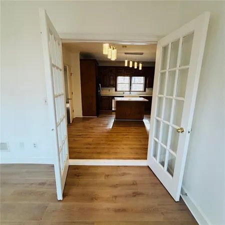 a view of a big room with wooden floor and windows