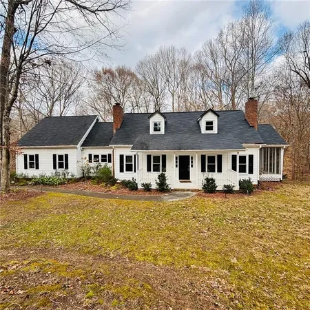 a front view of a house with a large tree
