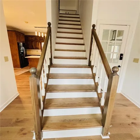 a view of a room with wooden floor a ceiling fan and windows