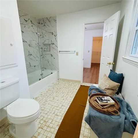 an empty room with wooden floor fireplace and windows