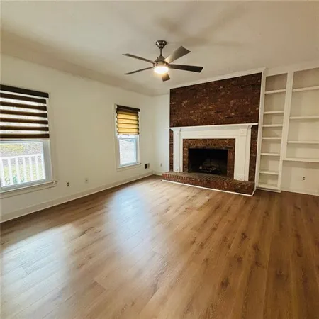 a kitchen with stainless steel appliances granite countertop a refrigerator a sink dishwasher a stove with wooden cabinets and a fireplace