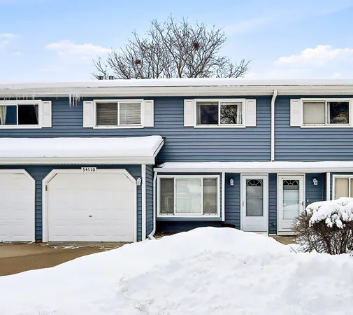 a front view of a house with a yard and parking space