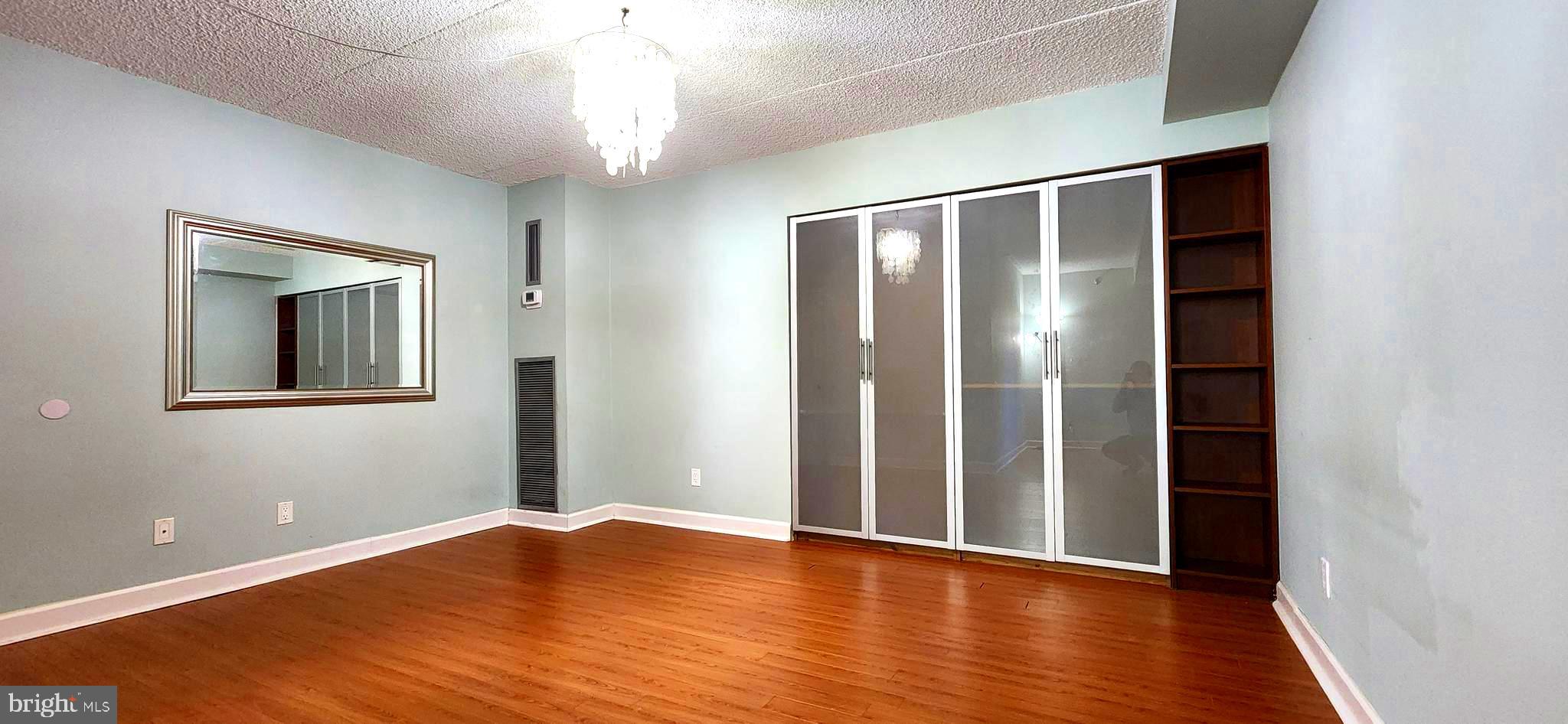 5911 Edsall Road, Unit 207 Alexandria, VA 22304 - Photo 11 of 22 a view of an empty room with wooden floor and a window