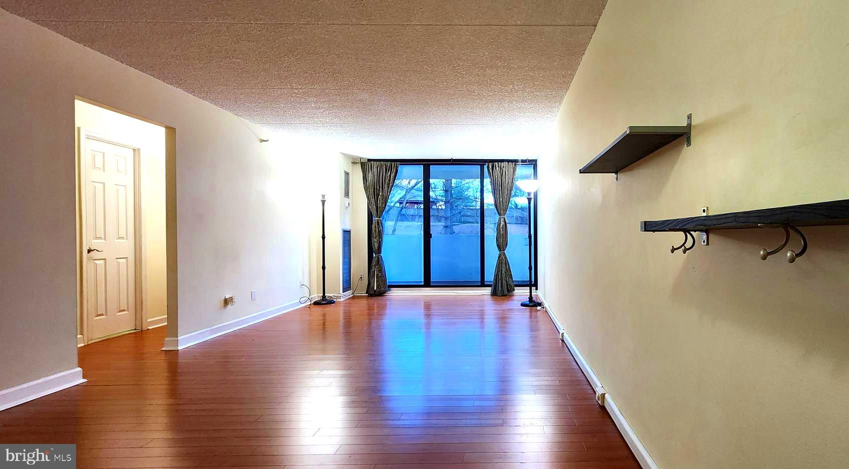 5911 Edsall Road, Unit 207 Alexandria, VA 22304 - Photo 5 of 22 a view of an empty room with wooden floor and a window