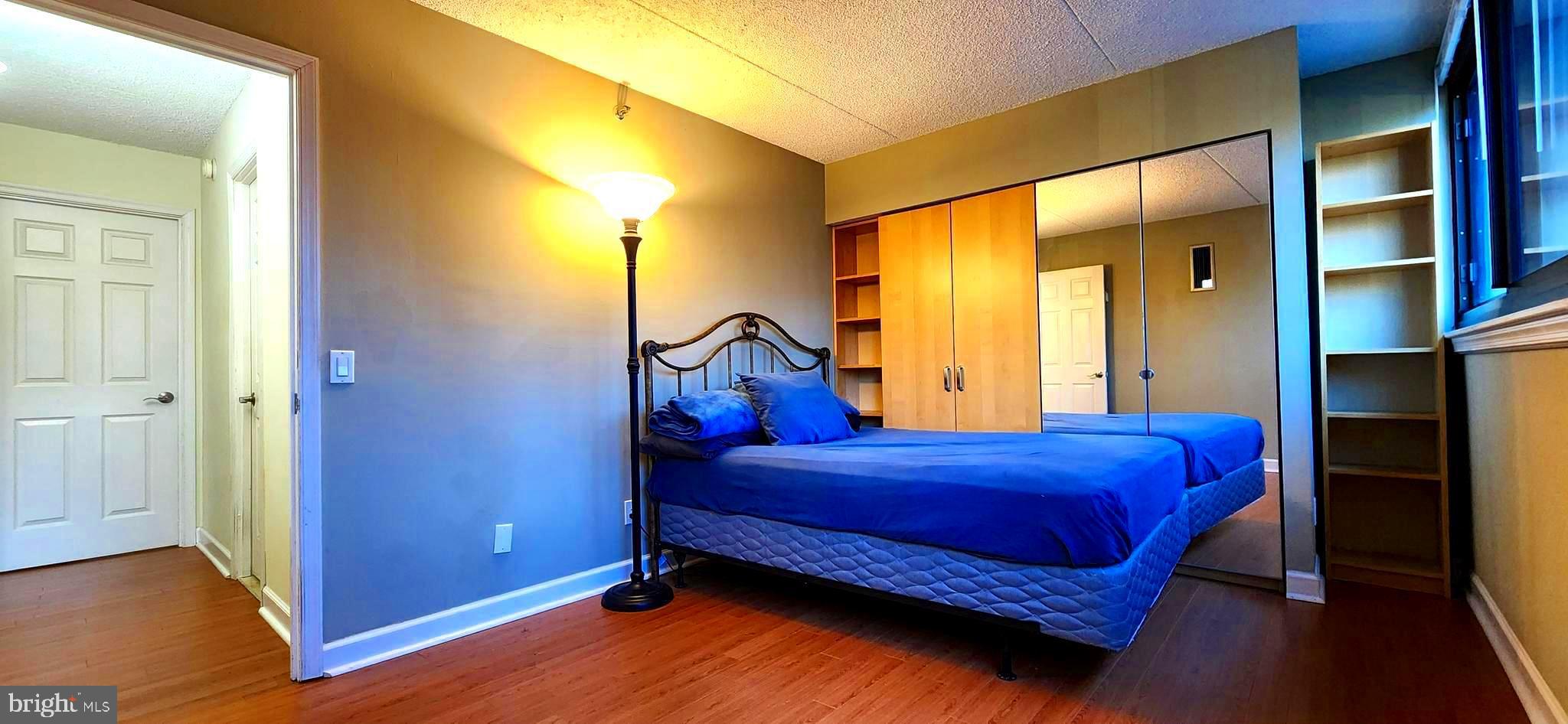 5911 Edsall Road, Unit 207 Alexandria, VA 22304 - Photo 9 of 22 a bedroom with a bed and wooden floor