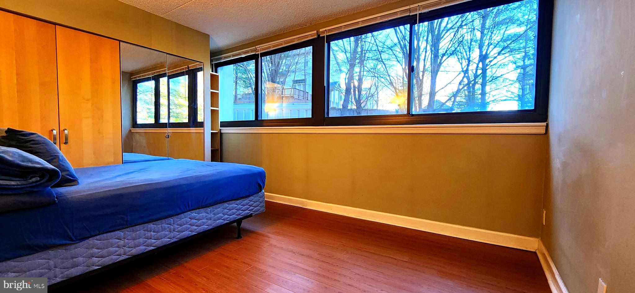 5911 Edsall Road, Unit 207 Alexandria, VA 22304 - Photo 10 of 22 a bedroom with a bed and wooden floor