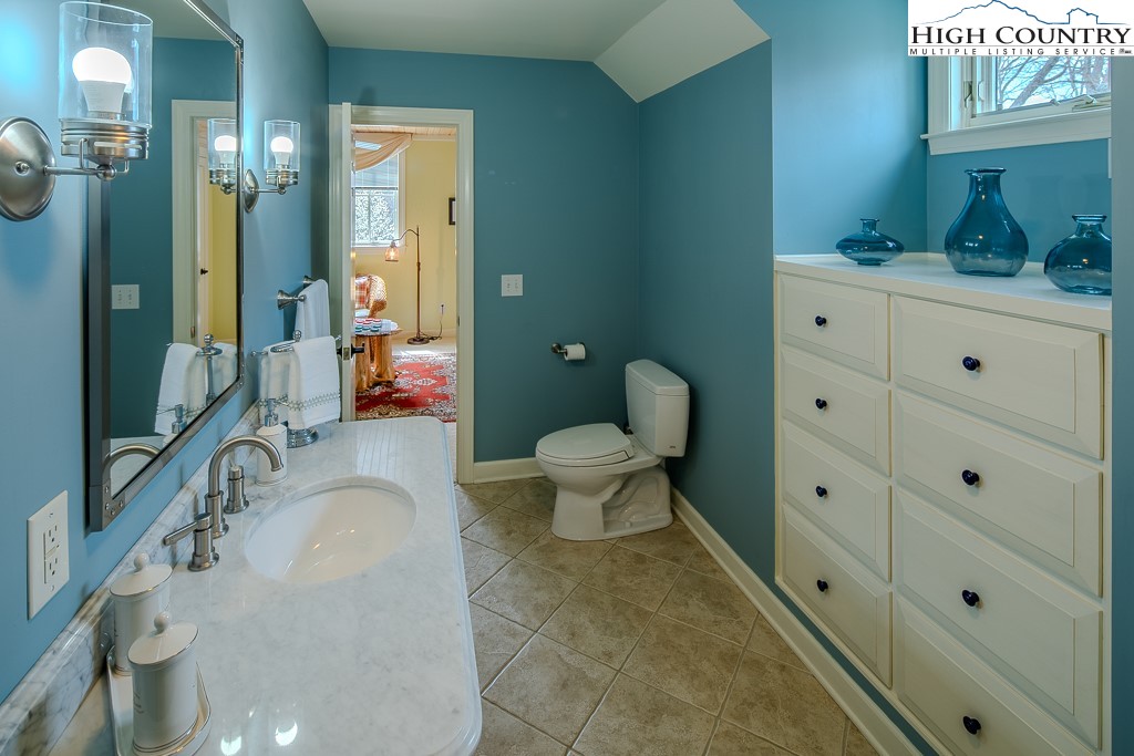 909 Daisy Ridge Road Banner Elk, NC 28604 - Photo 29 of 47 a spacious bathroom with a granite countertop toilet sink and mirror