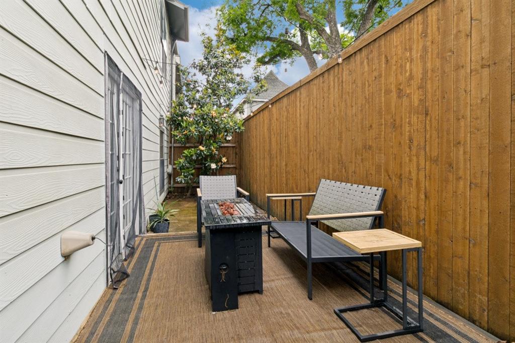 3904 Rawlins Street, Unit 112 Dallas, TX 75219 - Photo 15 of 15 Private outdoor patio featuring a wood privacy fence, siding exterior, and direct access through a glass-paneled door