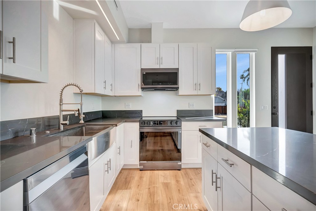 6721 Rhea Reseda, CA 91335 - Photo 4 of 22 a kitchen with granite countertop a sink stainless steel appliances and cabinets