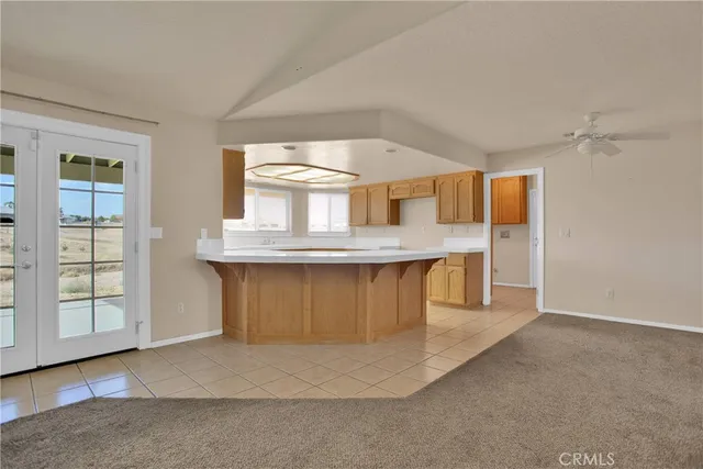 an empty room with kitchen cabinet and windows