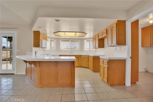 a spacious bathroom with a granite countertop sink a mirror and a bathtub