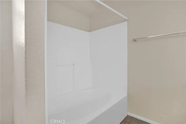 an empty room with chandelier fan and windows