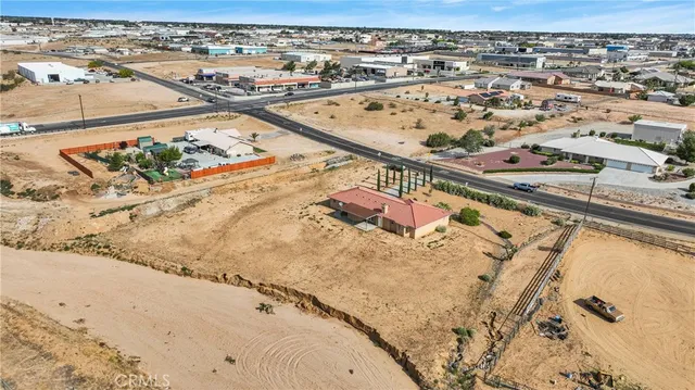 an aerial view of a house with a yard and wooden fence