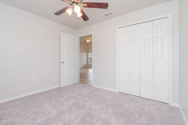 an empty room with fan and entrance