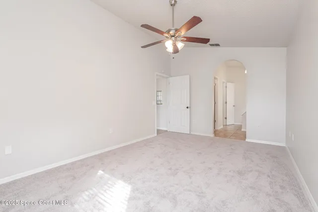 an empty room with a chandelier fan and a closet