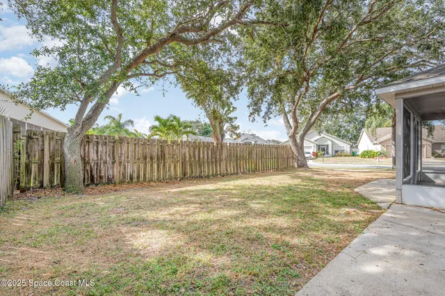 a backyard of a house with trees and outdoor seating