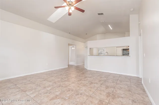an empty room with fan and windows