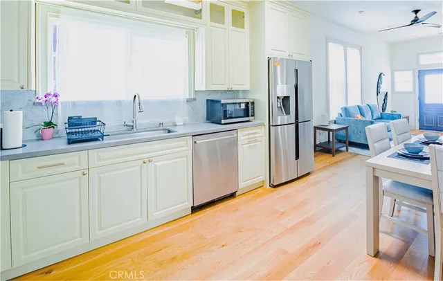 a kitchen with white cabinets and stainless steel appliances