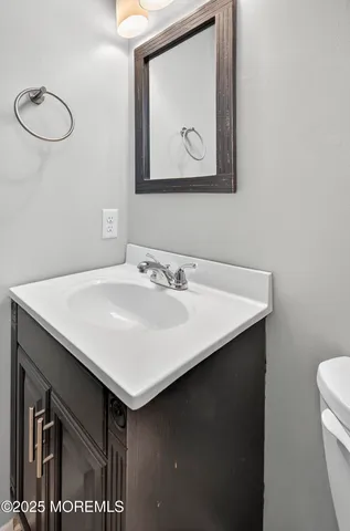 a bathroom with a sink vanity and a toilet