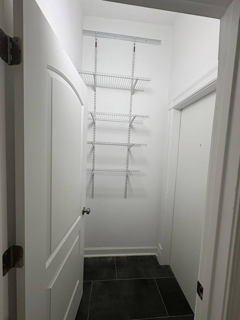 5136 South Blackstone Avenue, Unit 1F Chicago, IL 60615 - Photo 11 of 13 a view of storage and utility room with racks on the wall