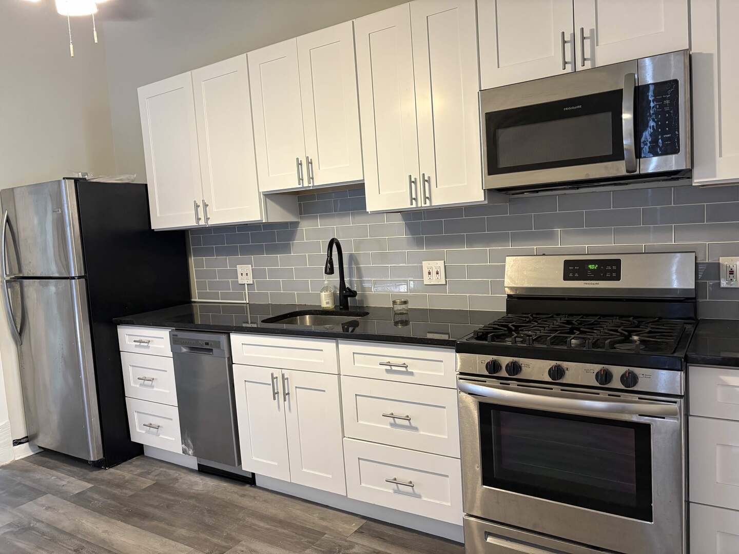 5136 South Blackstone Avenue, Unit 1F Chicago, IL 60615 - Photo 6 of 13 a kitchen with stainless steel appliances granite countertop a stove microwave and refrigerator