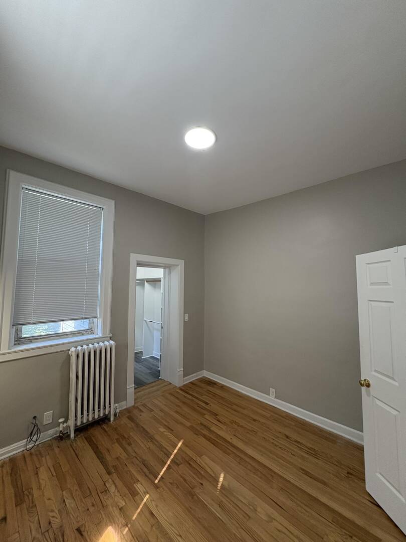 5136 South Blackstone Avenue, Unit 1F Chicago, IL 60615 - Photo 8 of 13 a view of an empty room with wooden floor and a window