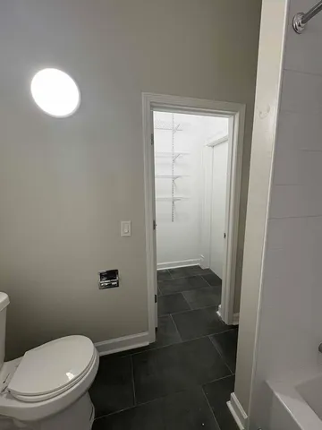 a white toilet sitting in a bathroom next to a sink
