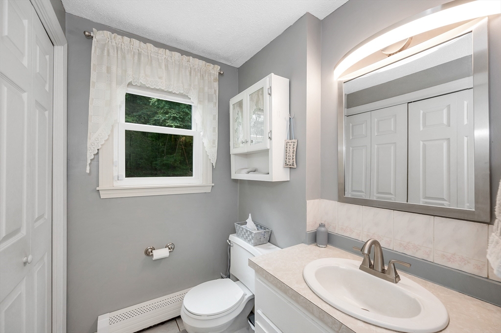 30 Partridge Road Dracut, MA 01826 - Photo 16 of 39 a bathroom with a toilet a sink and mirror
