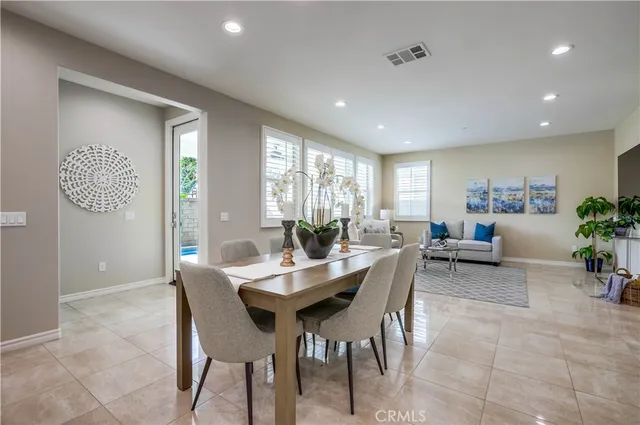 a kitchen with stainless steel appliances a sink dishwasher a refrigerator and a dining table with garden view