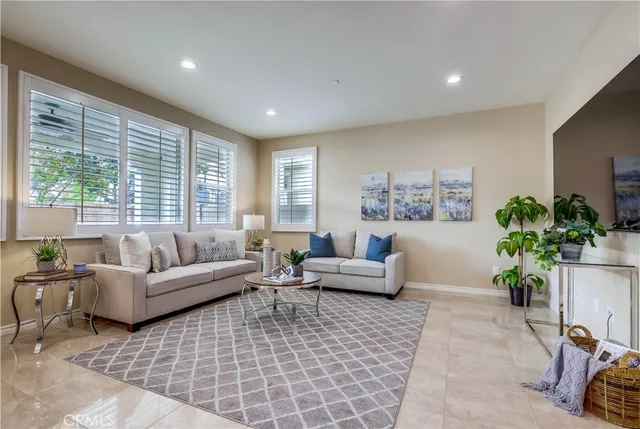 a living room with furniture potted plant and a large window