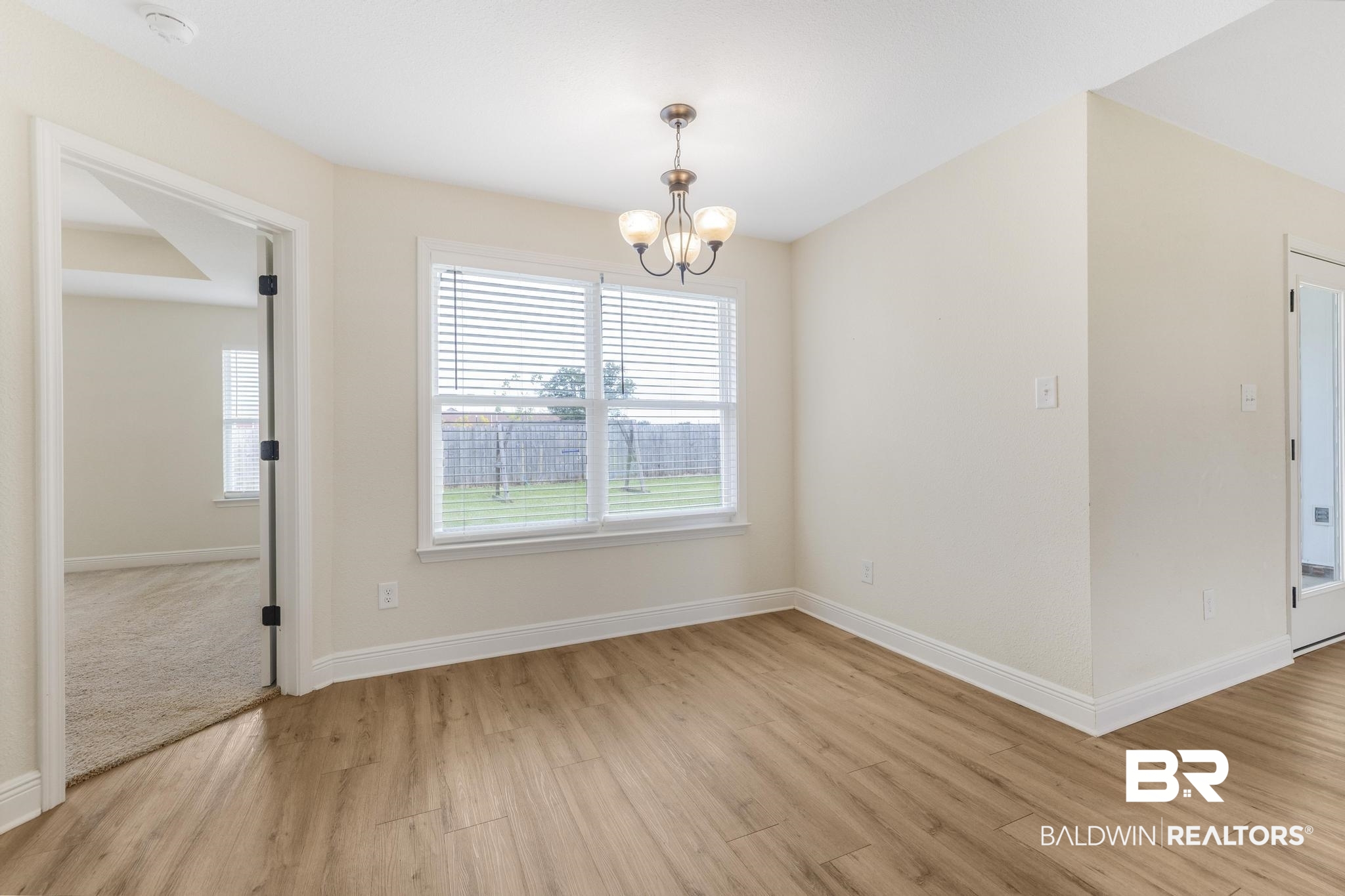 21580 Talbot Lane Robertsdale, AL 36567 - Photo 16 of 25 Unfurnished dining area featuring light wood-style flooring and a chandelier