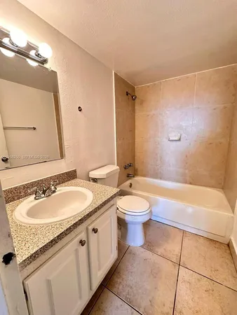 a bathroom with a granite countertop toilet and a sink