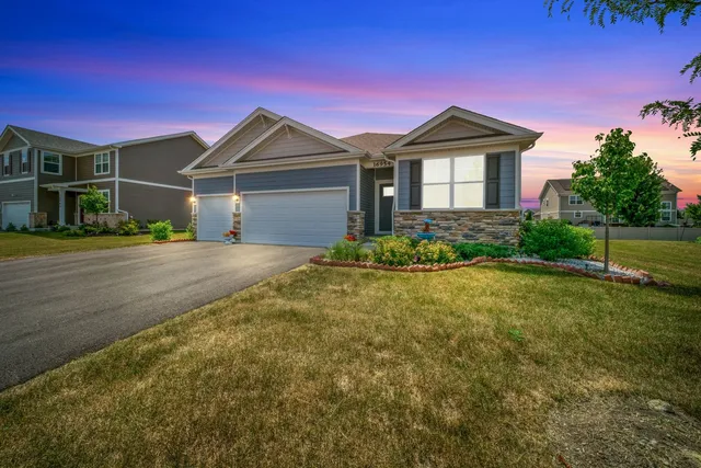 a front view of a house with a yard and potted plants