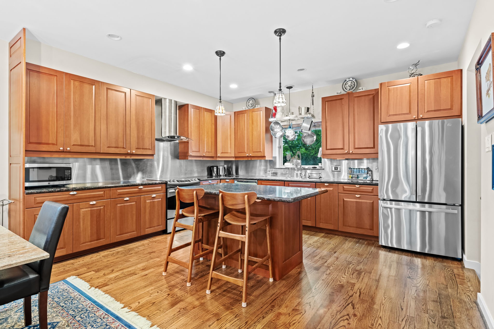 1820 Palm Street Houston, TX 77004 - Photo 46 of 47 a kitchen with stainless steel appliances granite countertop wooden cabinets a refrigerator a sink a stove a dining table and chairs