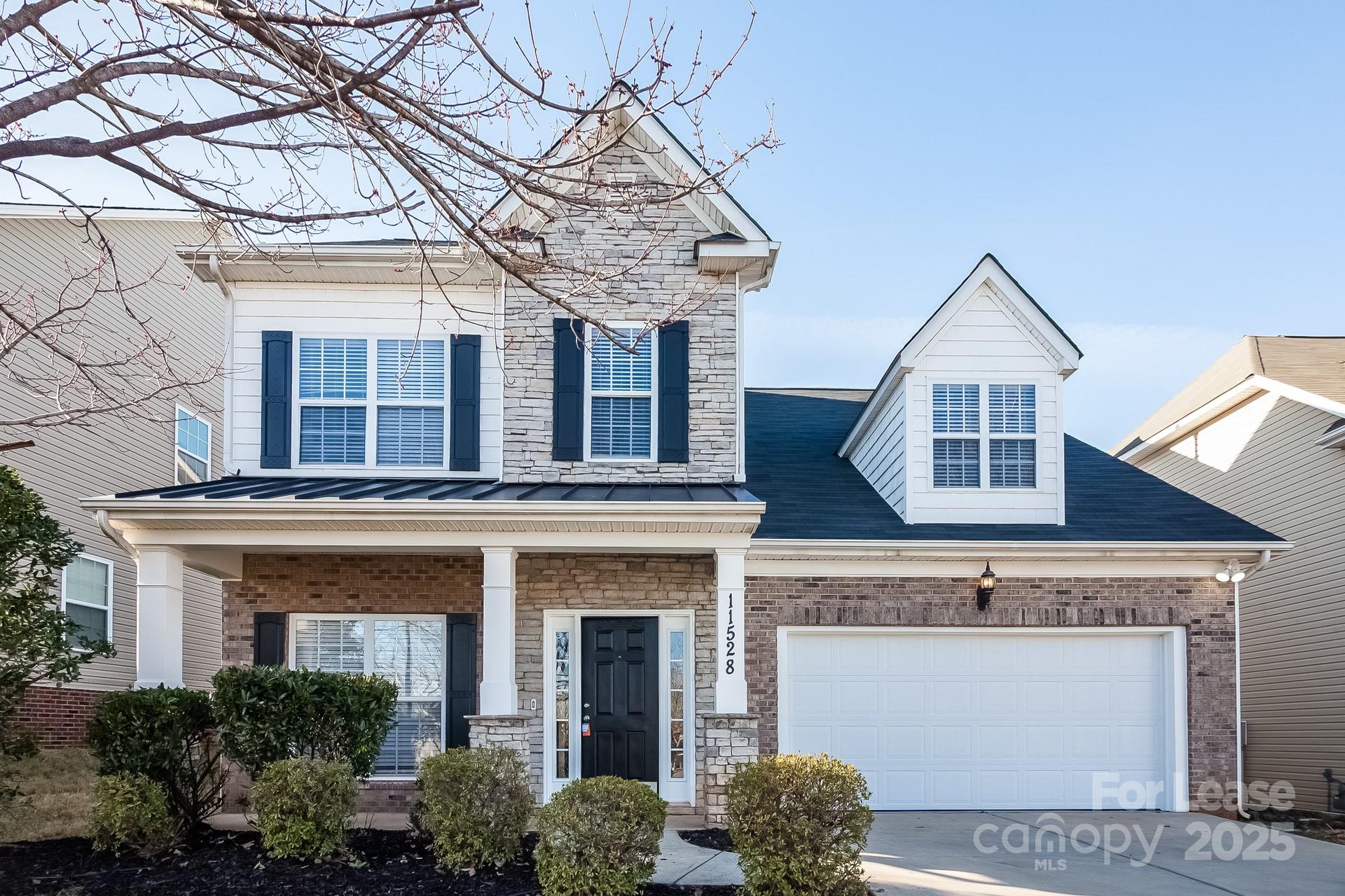 a front view of a house with a tree
