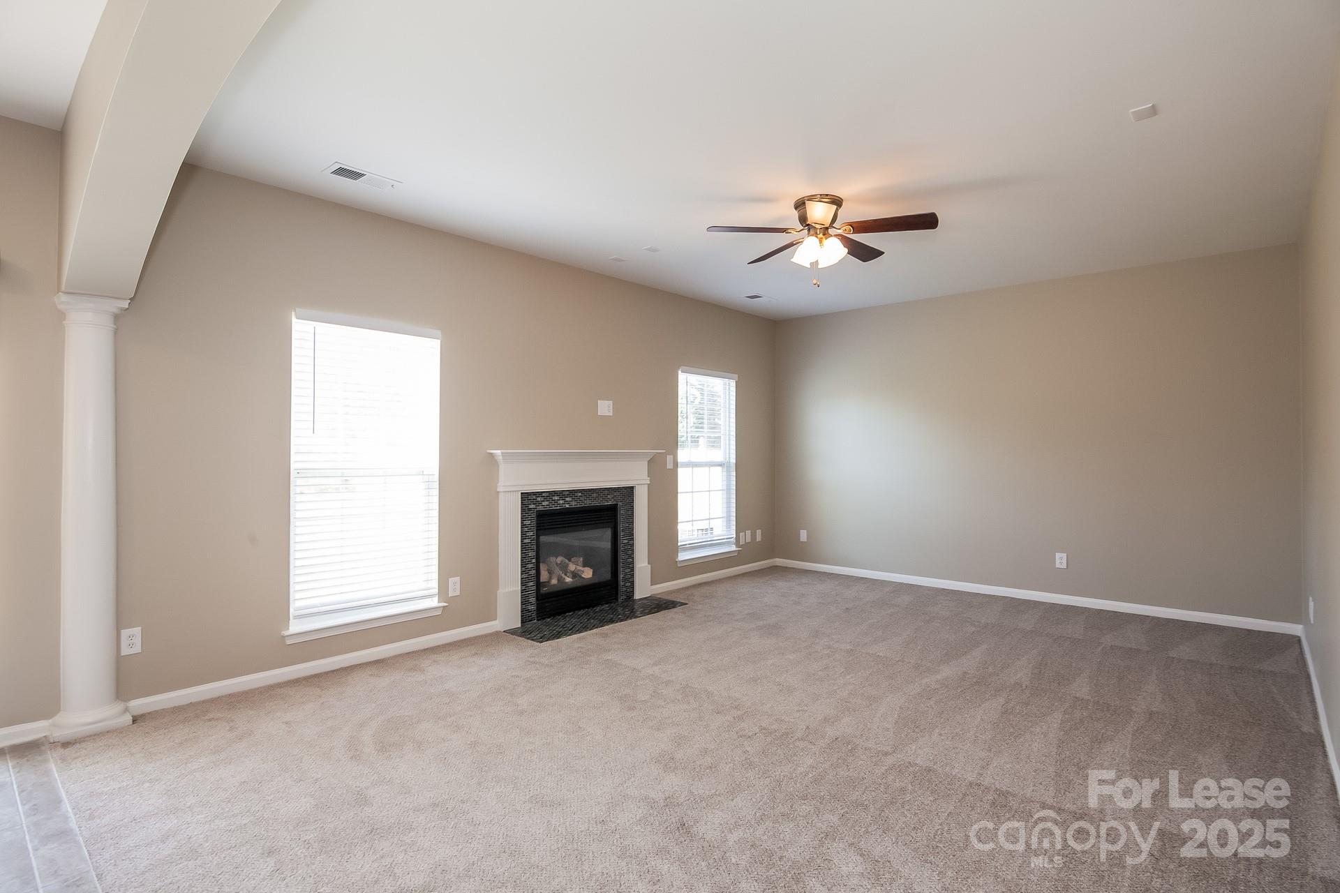 11528 Sidney Crest Avenue Charlotte, NC 28213 - Photo 2 of 15 an empty room with chandelier fan and fireplace