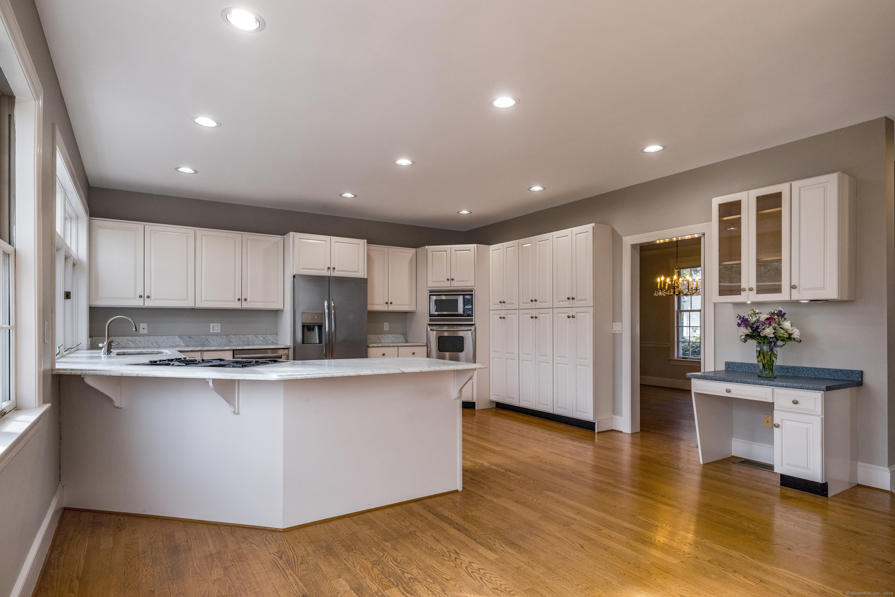 13 Longview Terrace, Unit 13 Madison, CT 06443 - Photo 11 of 31 a kitchen with stainless steel appliances granite countertop a stove top oven a sink a refrigerator and white cabinets with wooden floor