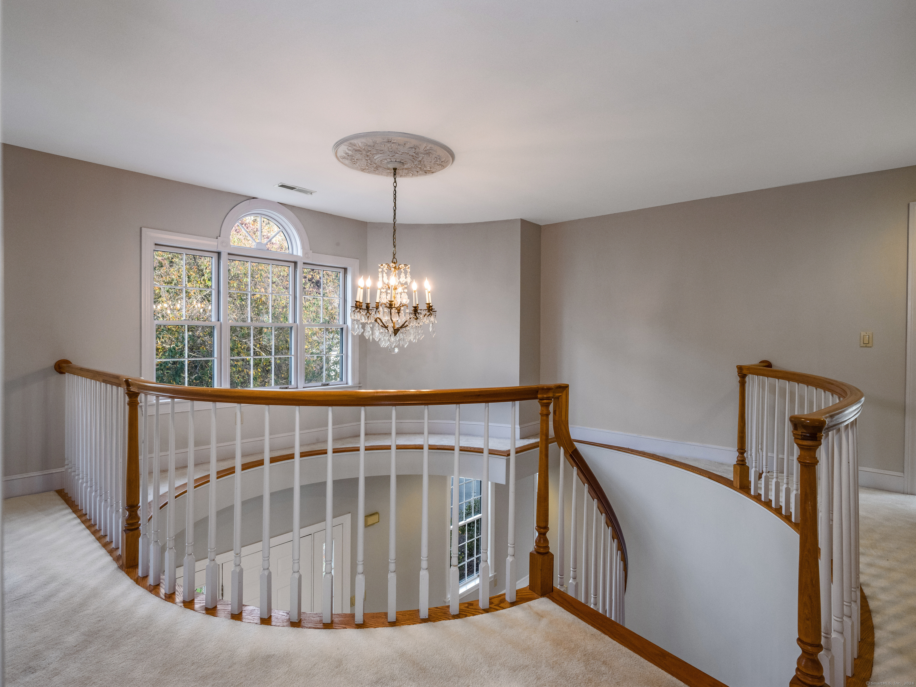 13 Longview Terrace, Unit 13 Madison, CT 06443 - Photo 13 of 31 a view of staircase with railing and a chandelier