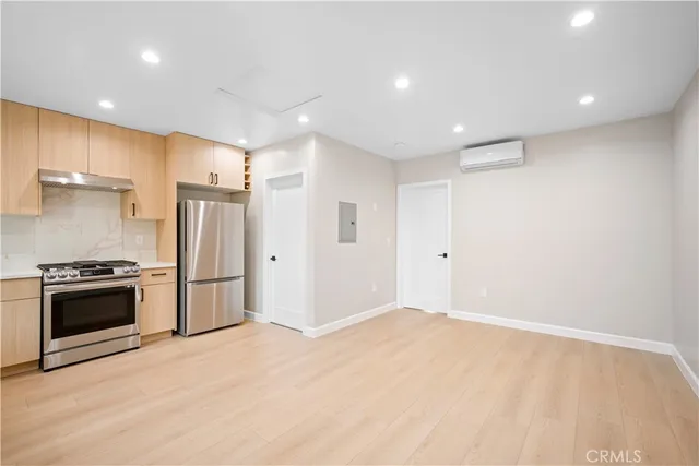 a large white kitchen with kitchen island a sink stainless steel appliances and cabinets