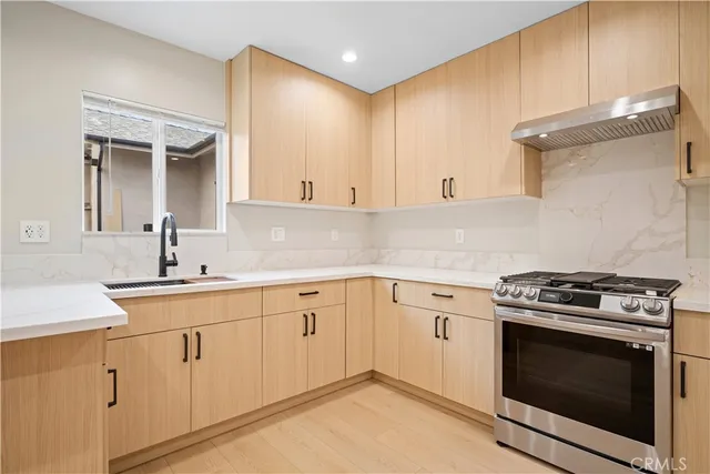 a kitchen with stainless steel appliances granite countertop a refrigerator a sink and wooden cabinets