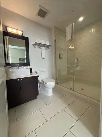a bathroom with a double vanity sink toilet and shower