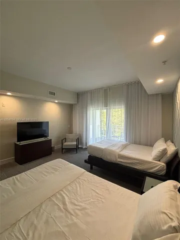 a spacious bedroom with two beds and a large window