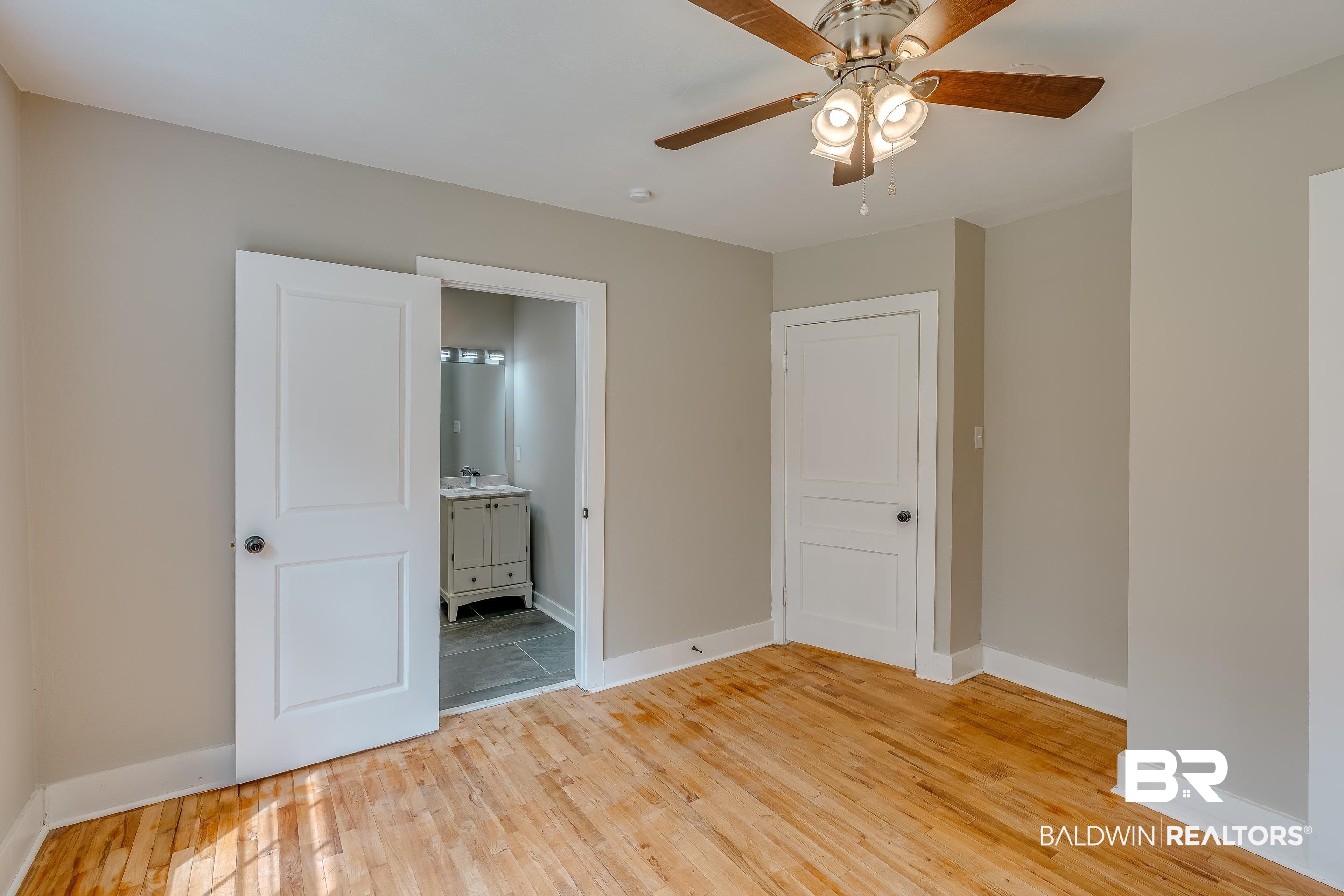 8001 16th Street Irvington, AL 36544 - Photo 22 of 35 Unfurnished bedroom with light wood-type flooring, ensuite bath, and a ceiling fan