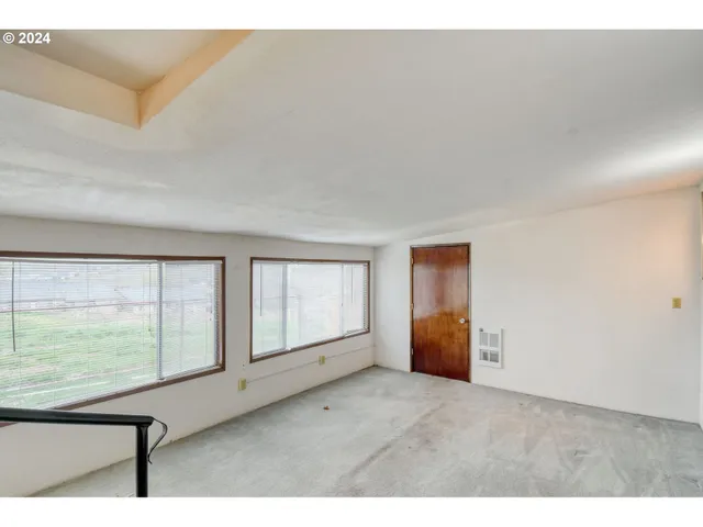 a view of an empty room with closet and a window