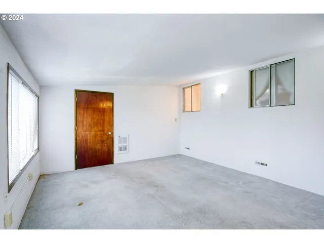 a view of an empty room with closet and a window