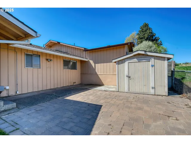 a view of a backyard with plants and brick wall